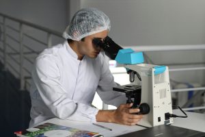 A scientist looking into a microscope