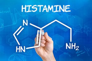 Hand with pen drawing the chemical formula of histamine
