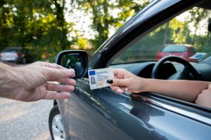A driver showing her drivers license to an officer.