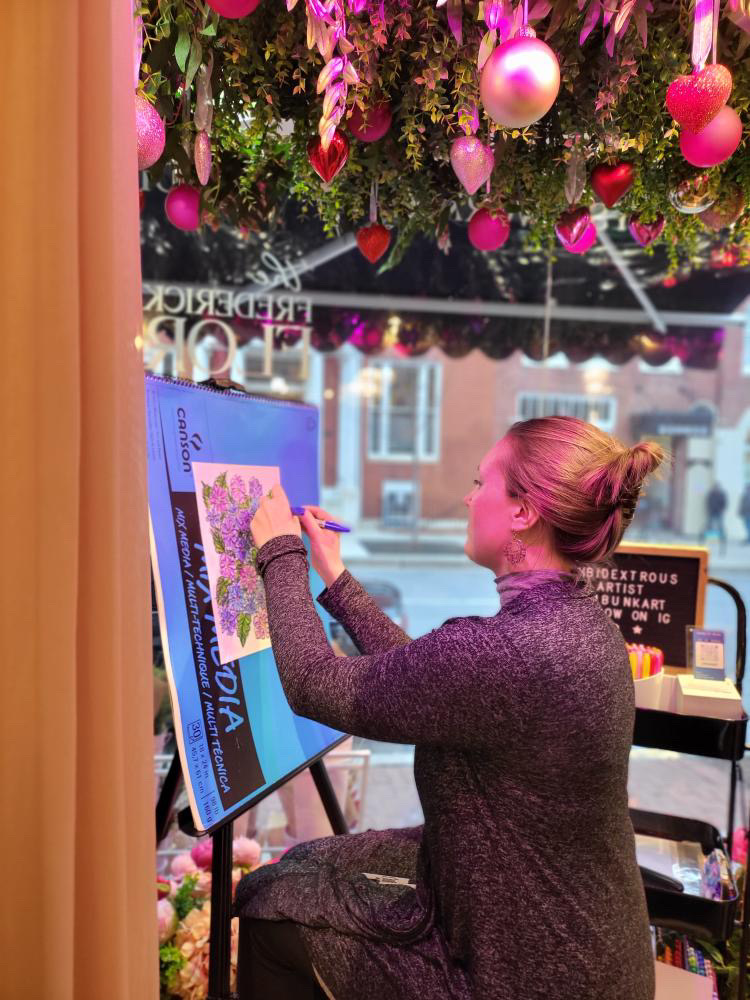 Jessie Bunk making art on an easel in a sunroom 