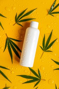 conditioner on cannabis leaf background