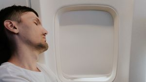 man sleeping on flight