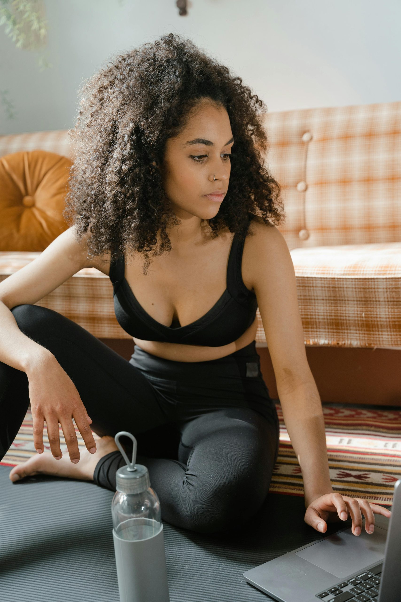 woman exercising while looking at laptop
