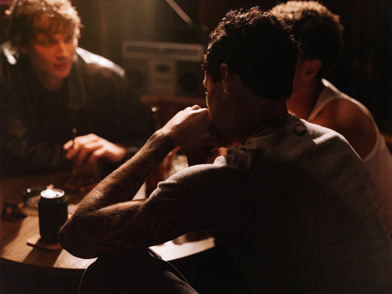 group sitting around a table talking and smoking